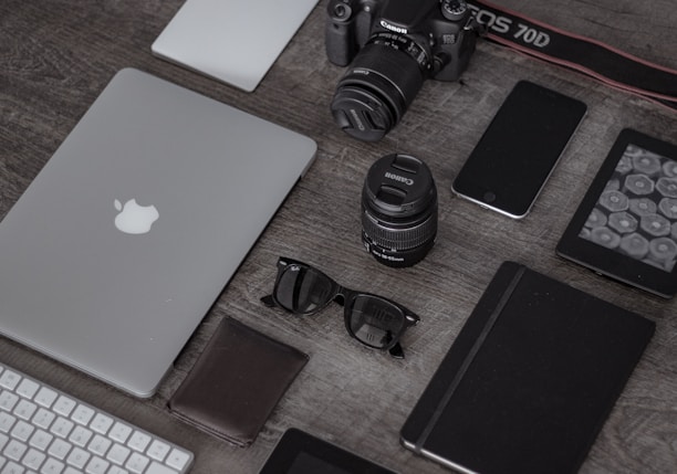 iPad near sunglasses, wallet, and DSLR camera