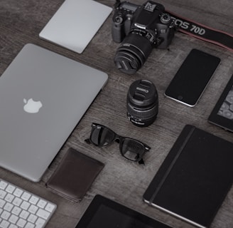 iPad near sunglasses, wallet, and DSLR camera