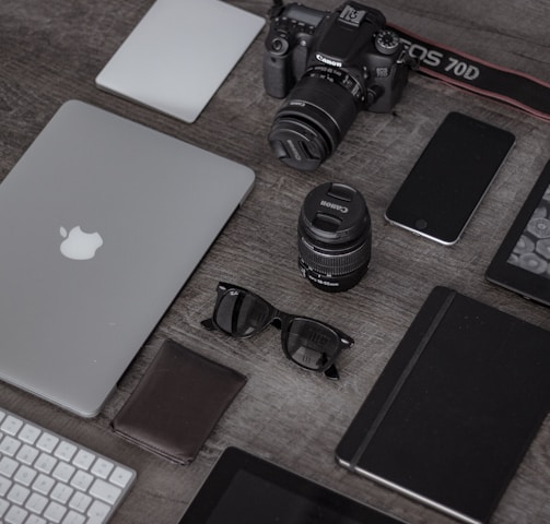 iPad near sunglasses, wallet, and DSLR camera