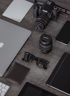 iPad near sunglasses, wallet, and DSLR camera