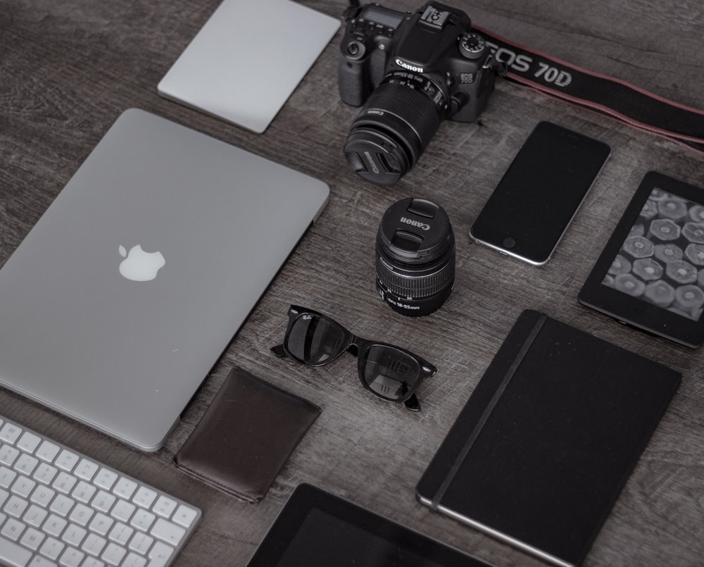 iPad near sunglasses, wallet, and DSLR camera