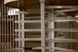 A metallic structure with bars and a circular section, resembling a turnstile, is situated within an industrial or institutional setting.