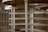 A metallic structure with bars and a circular section, resembling a turnstile, is situated within an industrial or institutional setting.