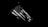 An American flag is displayed against a stark black background, with its stars and stripes prominently visible in high contrast black and white.