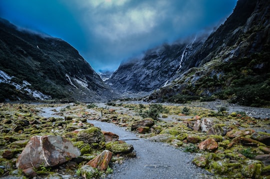 river near mountain under blue sky in Westland Tai Poutini National Park New Zealand