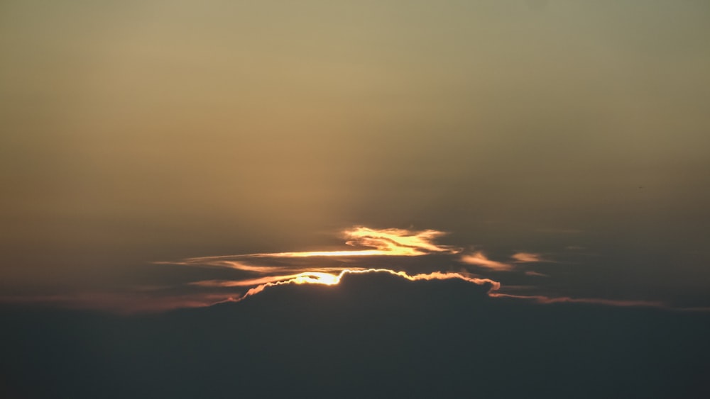 Il sole sta tramontando dietro una nuvola nel cielo