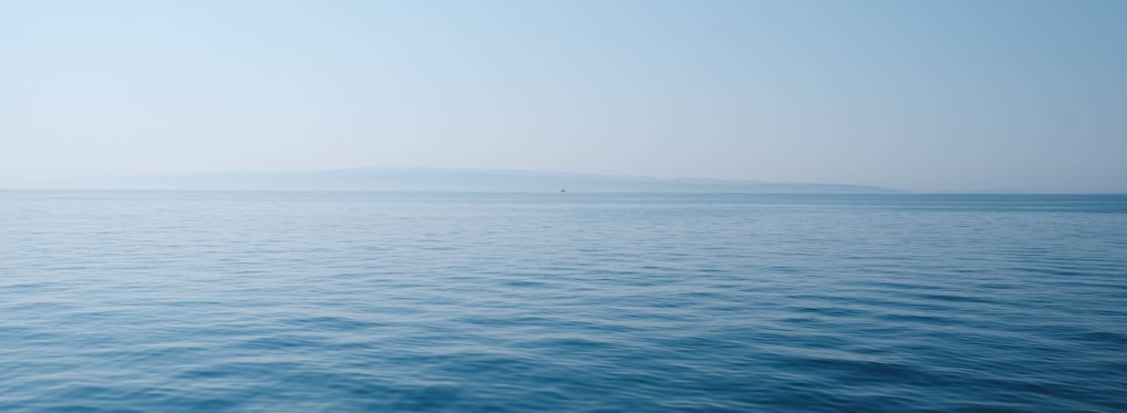 body of water under blue and white sky at daytime