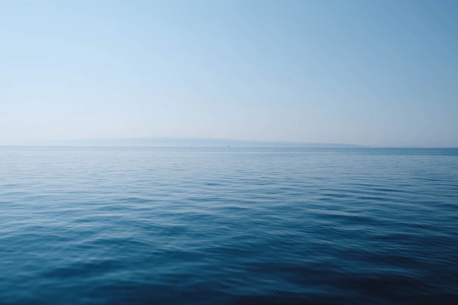 Scafo a vela su acqua scura, luce bassa