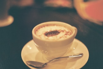 A creamy cappuccino topped with frothy milk and a sprinkle of cinnamon in a cozy café setting.