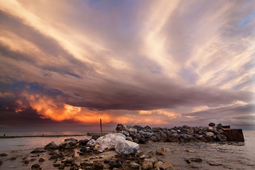 Pila de piedras cerca de la orilla del mar bajo el cielo nublado