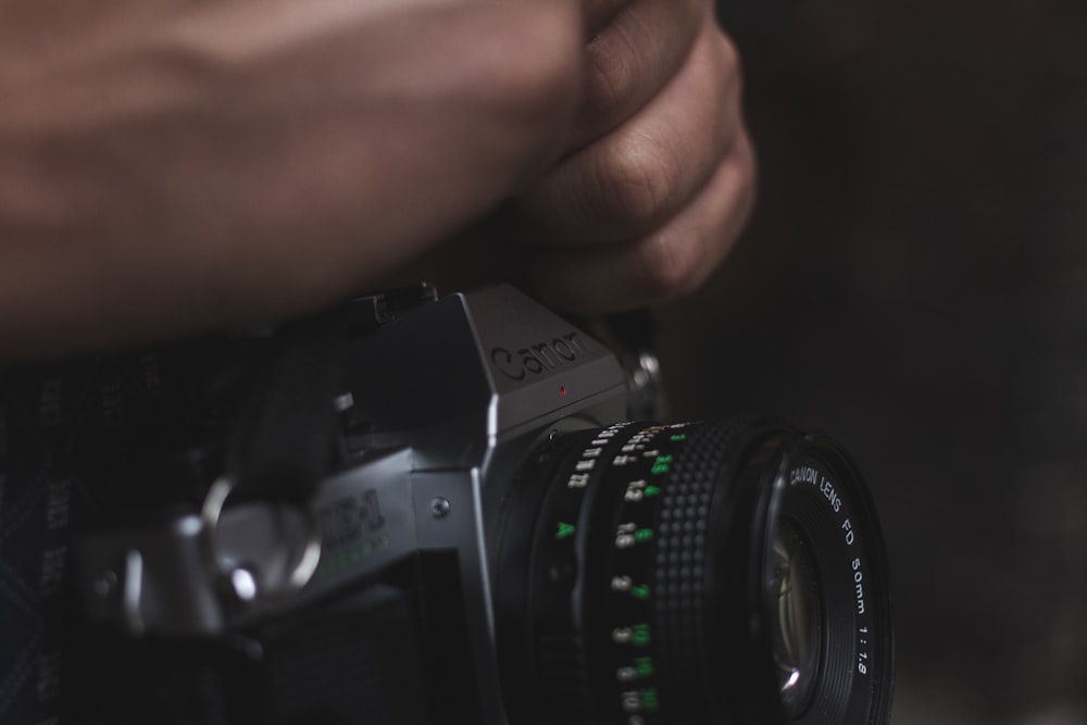 person holding black DSLR camera