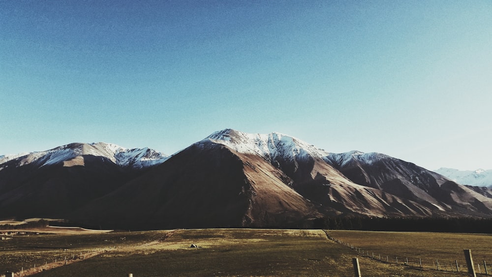 photo of mountain and green field