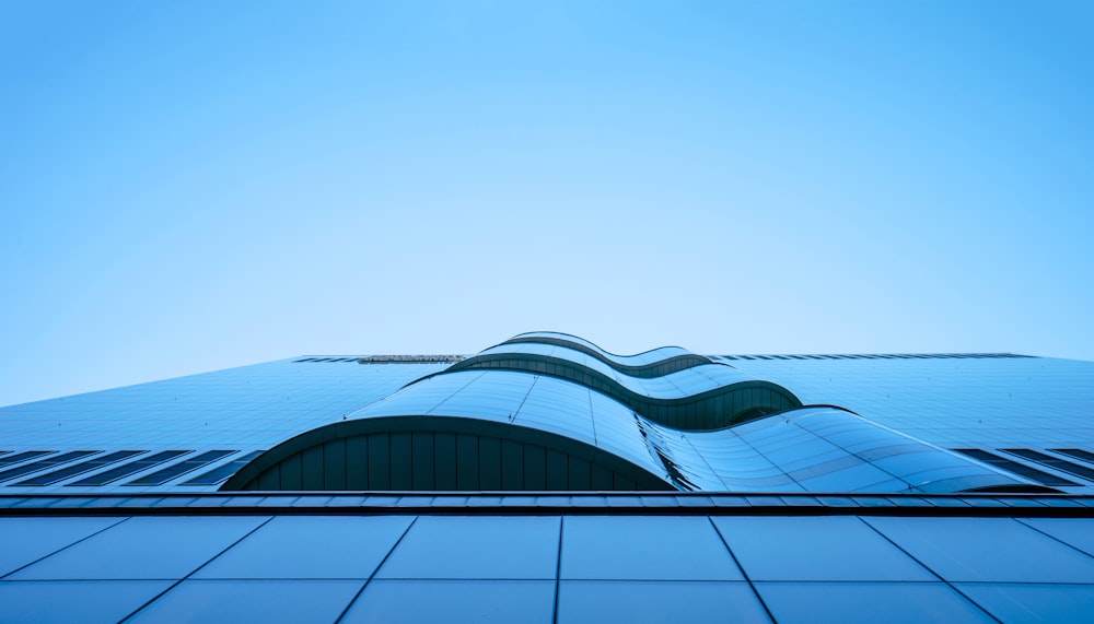 Fotografía de ángulo bajo de un edificio de gran altura bajo el cielo azul y blanco durante el día