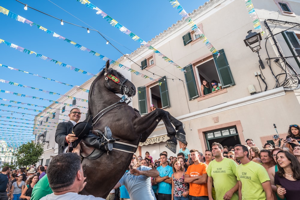 man riding house between people and building