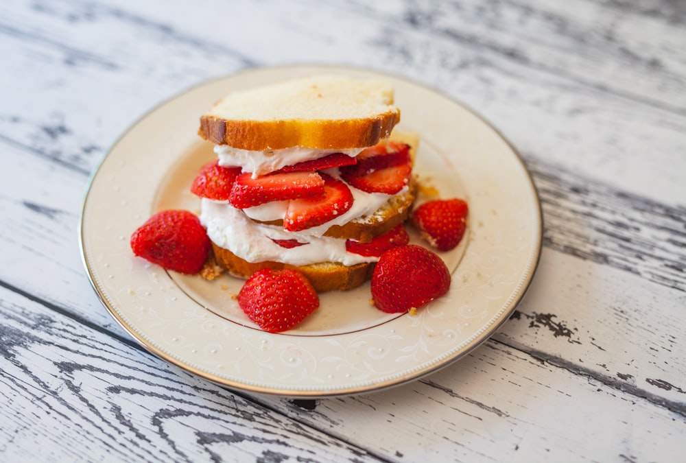 bread with cream and strawberry slices on plate