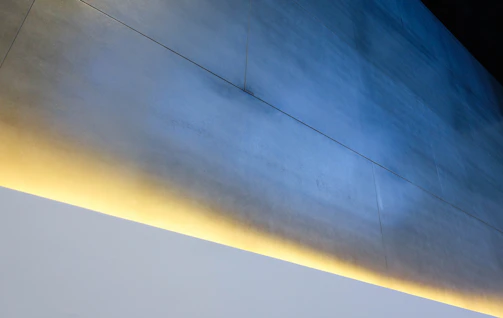 A sleek modern office interior with dark minimalist design and soft blue lighting accents.