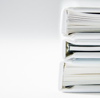 A stack of thick folders on a white surface