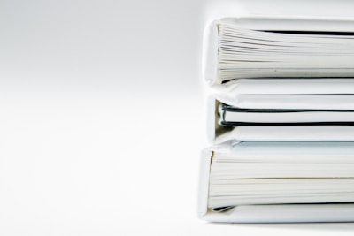 A stack of thick folders on a white surface