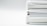 A stack of three white binders is neatly arranged on a white surface. The focus is on the spines and edges of the binders, showing their thickness and the neatly stacked pages within each binder.