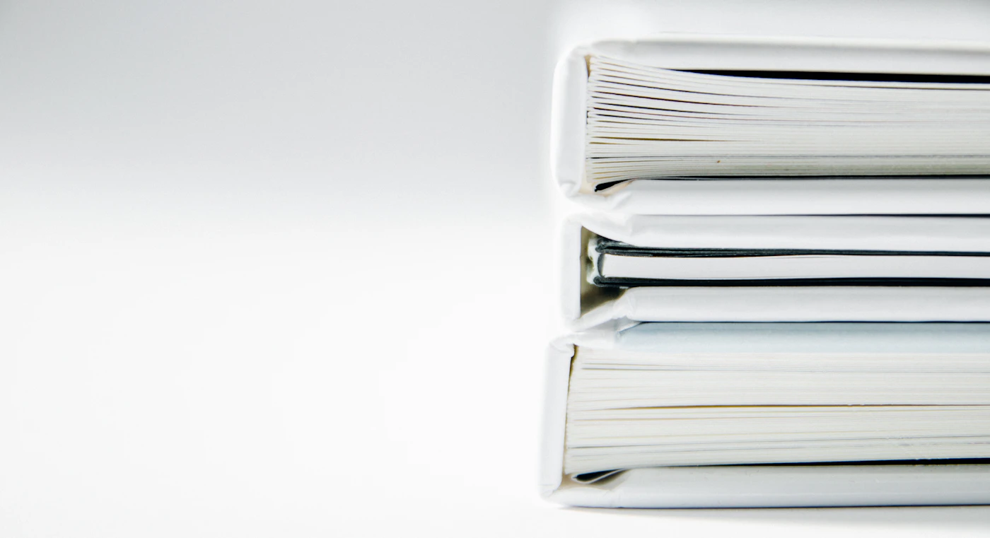 A stack of business entity folders on a desk representing LLC and S-Corp structures