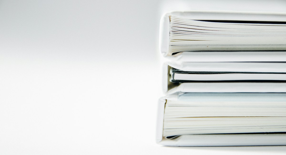 Une pile de chemises cartonnées de couleur, comme les dossiers physiques à déposer par les admis aux concours