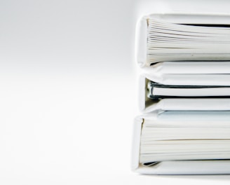 A stack of thick folders on a white surface