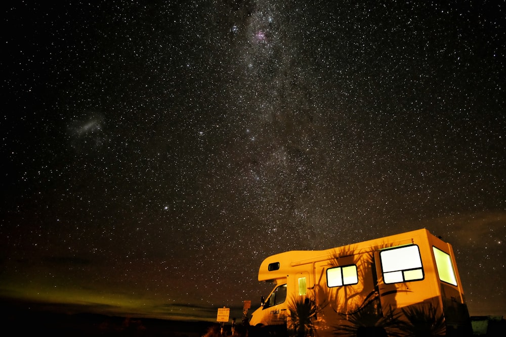 Foto de un vehículo blanco y marrón durante la noche con estrellas