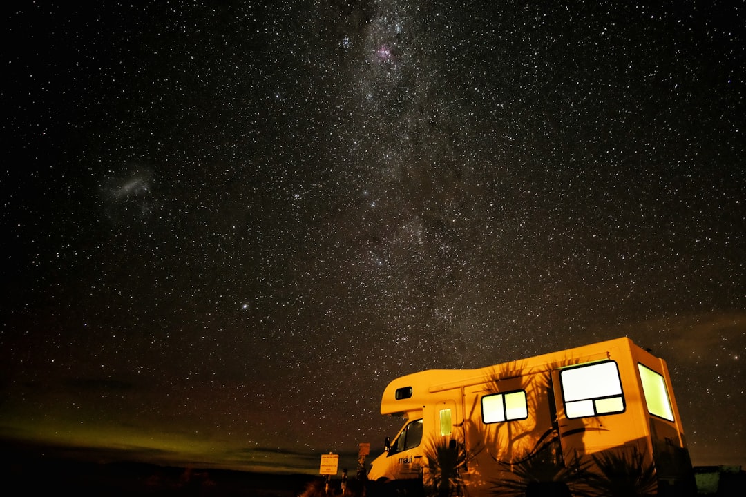 photo of white and brown vehicle during night time with stars