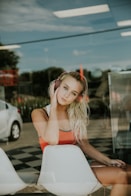 woman sits on chair behind glass wall