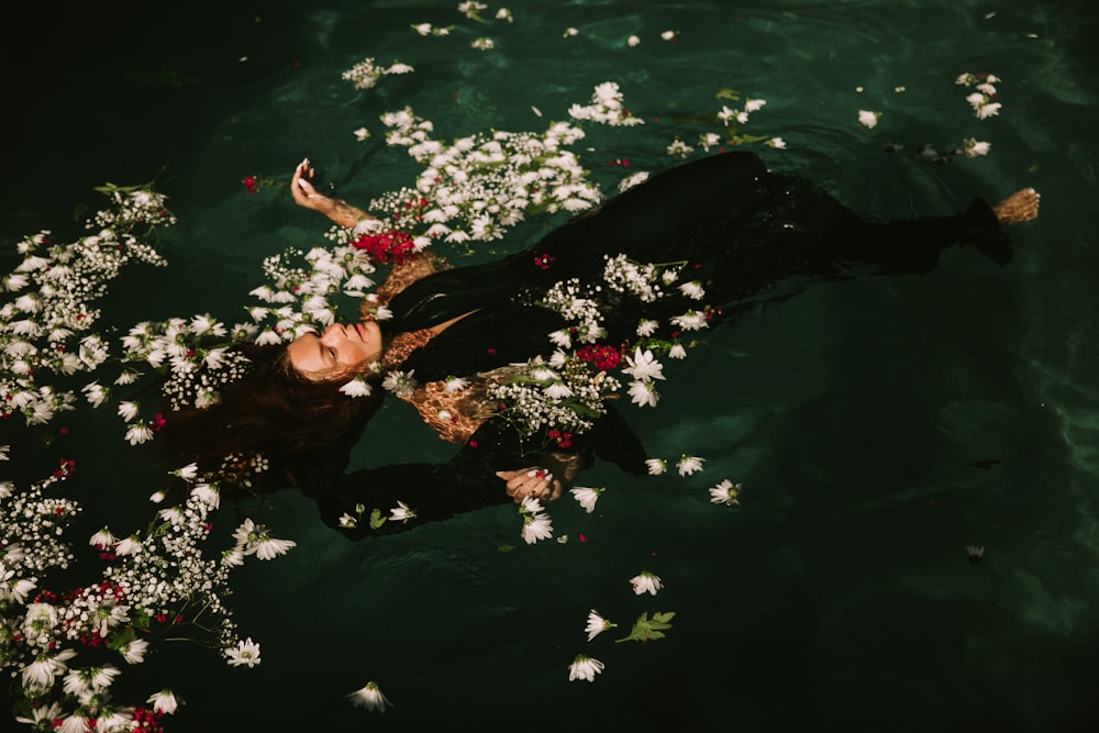 femme portant un costume noir flotte sur l’eau