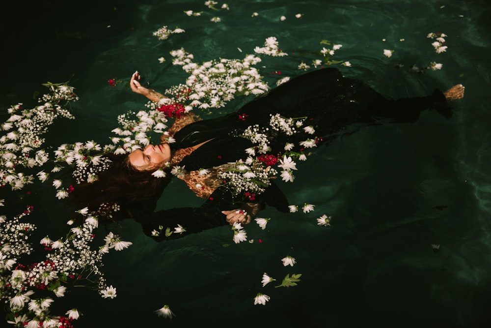 Frau im schwarzen Anzug schwimmt auf dem Wasser