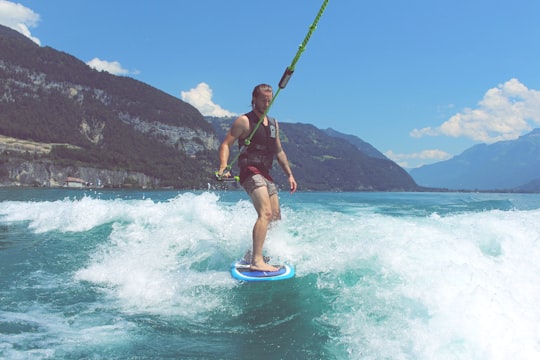 man wakeboarding on blue sea under blue and white skies in Thun Switzerland