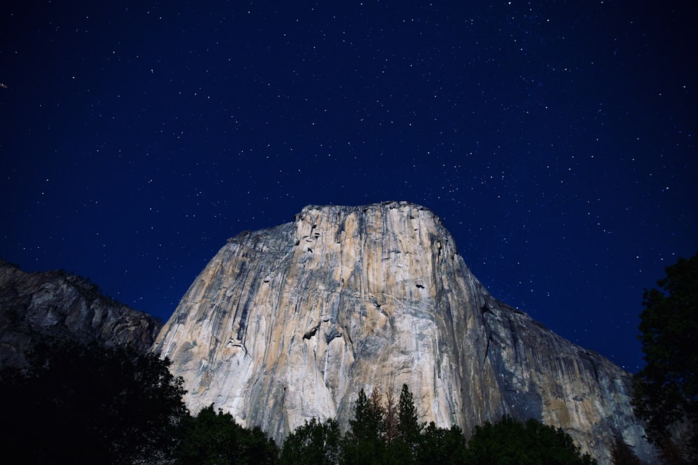 Photographie en contre-plongée des montagnes grises la nuit