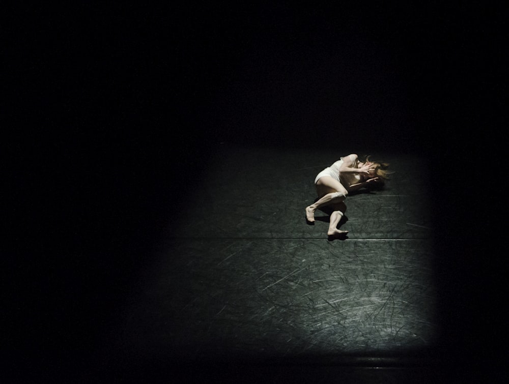 a person standing on a tennis court in the dark