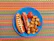 Close-up of a colorful hotdog topped with mustard and relish, styled with retro diner elements.