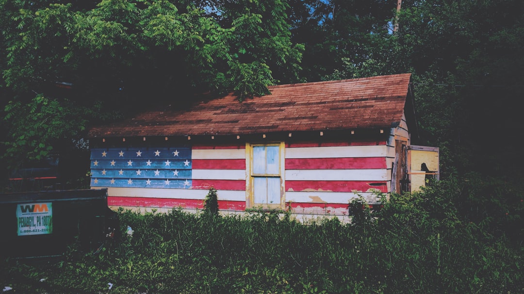 Small old house with American Flag painted on the front.