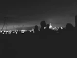 Silhouettes of professionals discussing ideas against a backdrop of a city skyline.