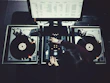 Close-up of DJ Nijgman mixing tracks on vinyl with focused intensity.
