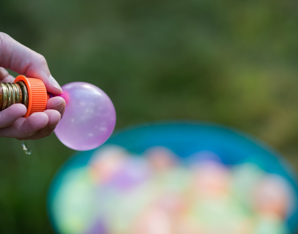 a person is holding a bottle and a balloon