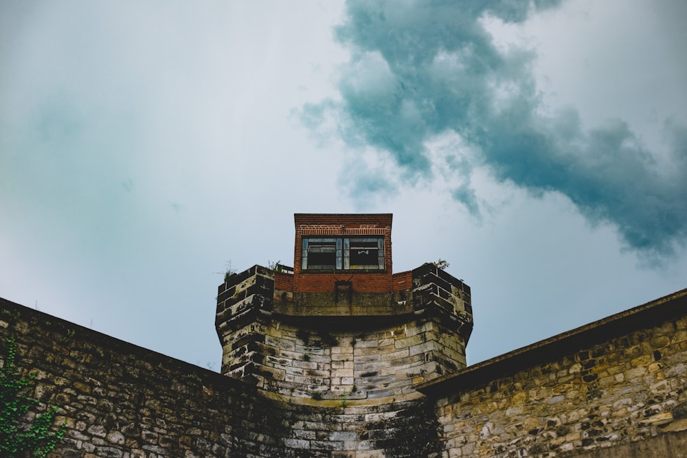 brown brick building under white clouds