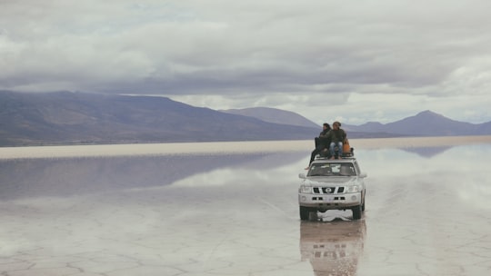 people on silver vehicle under gray sky during daytime in Uyuni Bolivia