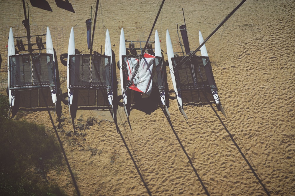 four white pontoon boats on beige sand