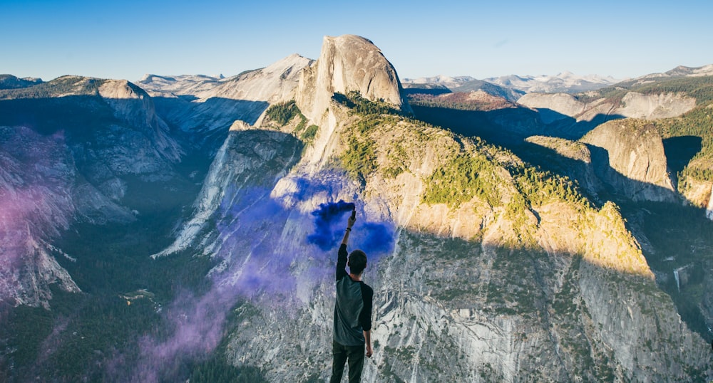 person wearing gray shirt facing gray mountain