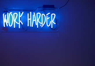 blue Work Harder neon signage