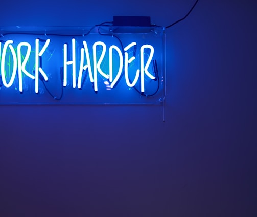 blue Work Harder neon signage