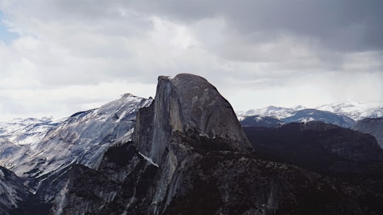 photo of black and white mountain with snow during daytime in Yosemite National Park United States