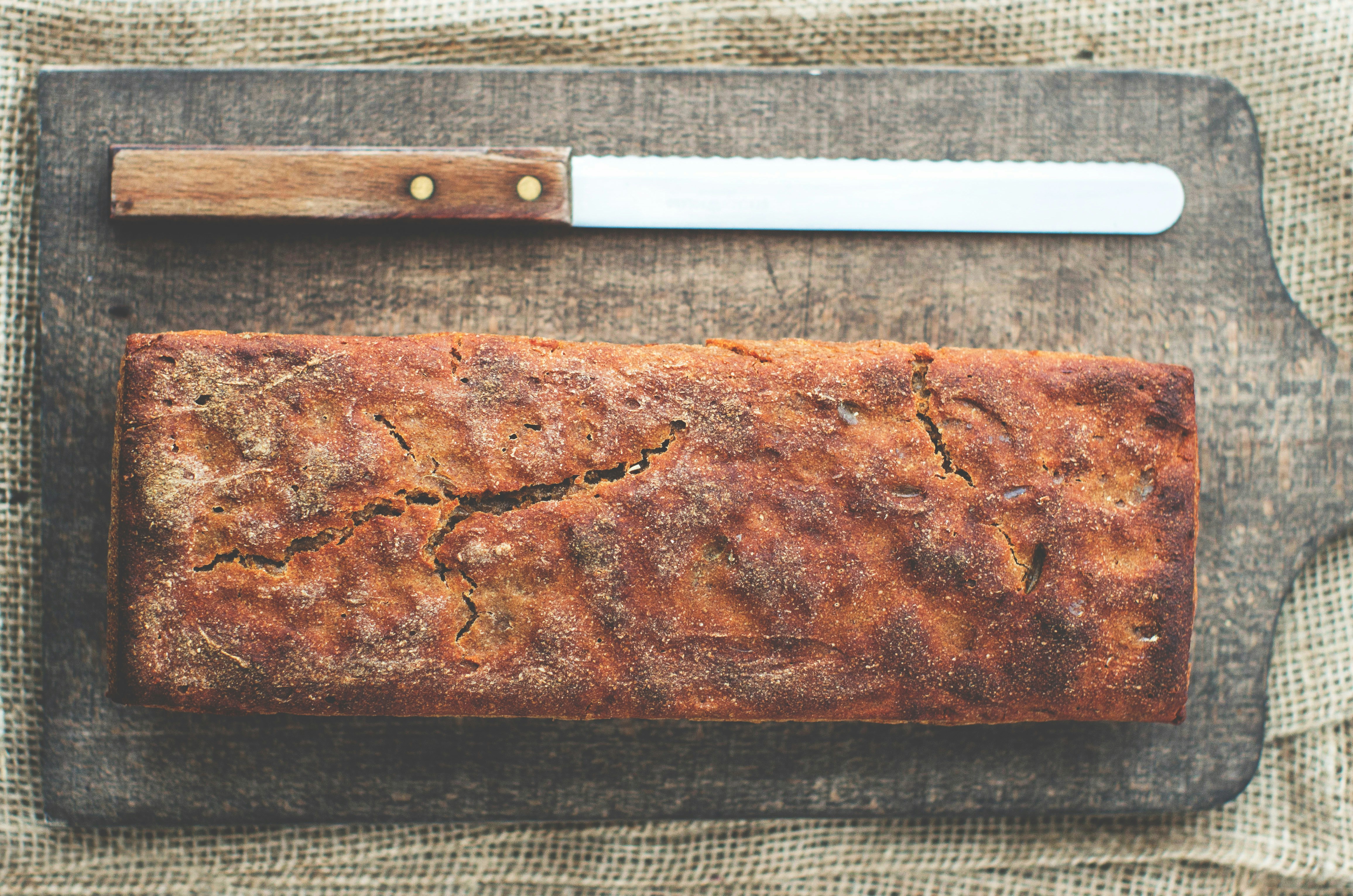 Freshly baked bread on a cutting board with a bread knife