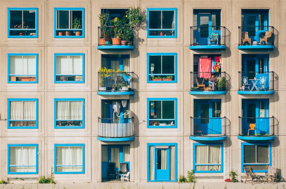 An apartment building with blue windows and balconies filled with plants in Amsterdam, Bullewijk
