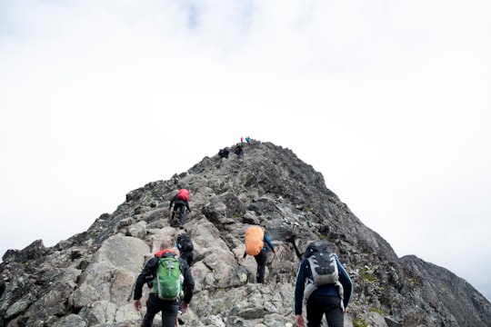 climbers hiking through mountain peak during daytime in Besseggen Norway