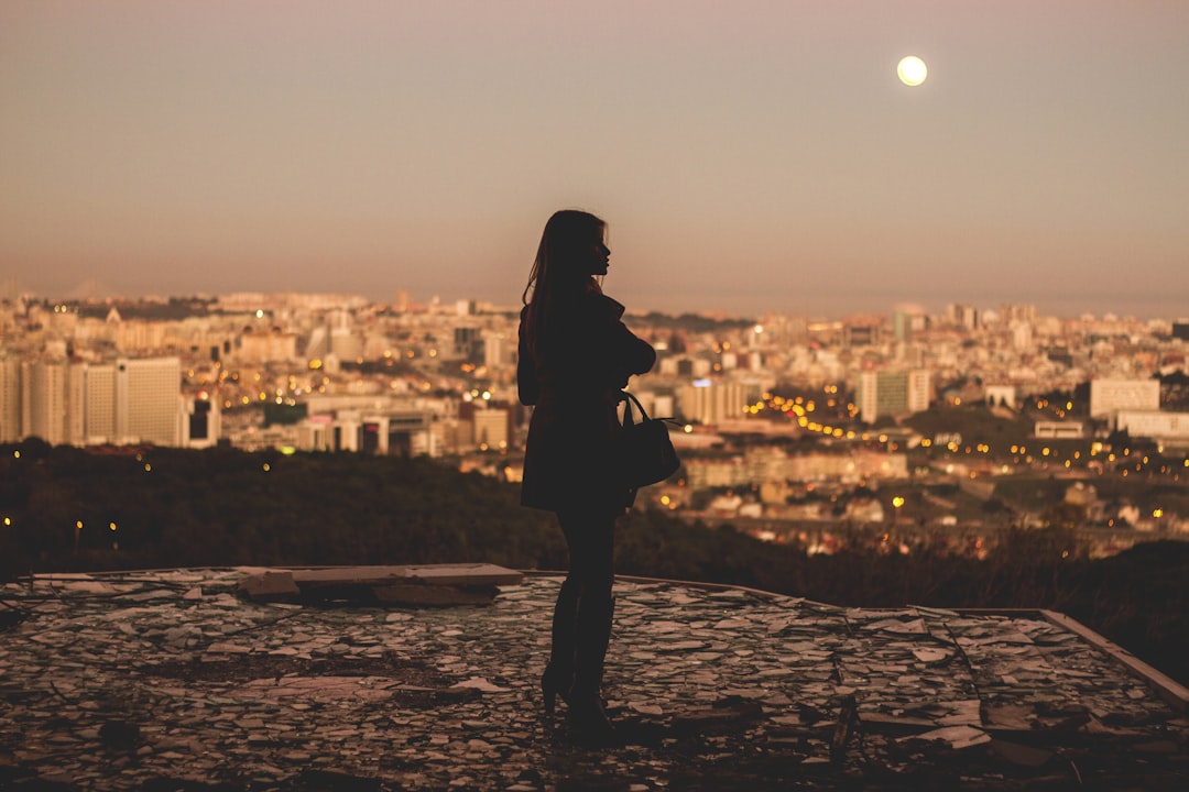 silhouette of woman standing during golden hour photography, Woman overlooking Lisbon sunset